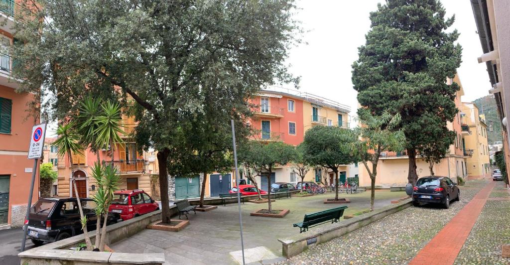 een stadsstraat met geparkeerde auto's, bomen en gebouwen bij Ca du Sergio - Il Mesco in Levanto