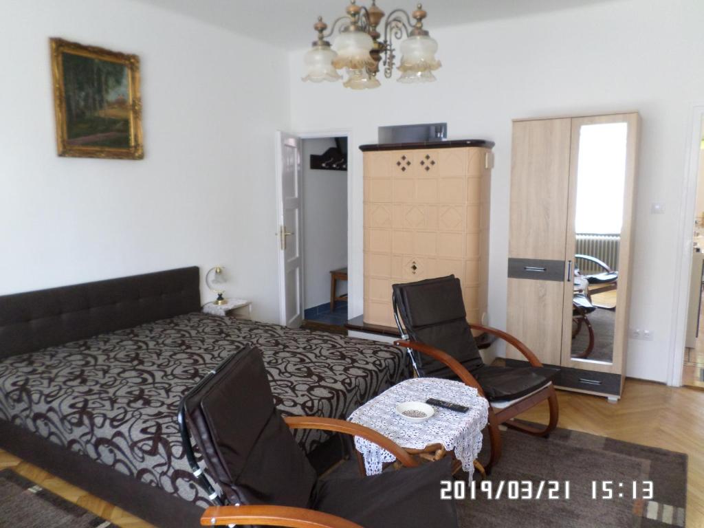 ソンバトヘイにあるRita apartmanのベッドルーム1室(ベッド1台、椅子2脚、テーブル付)