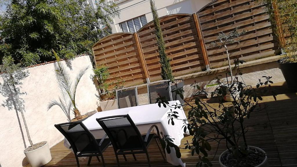 - une table et des chaises blanches sur la terrasse dans l'établissement les Pénates appartement terrasse, à Saint-Max
