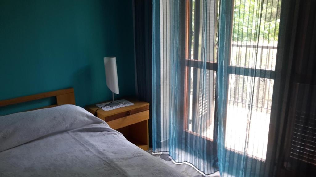 um quarto com uma cama e uma grande janela em Casa Marinella em Montecorice