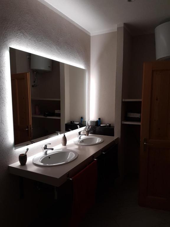 een badkamer met 2 wastafels en een grote spiegel bij Ciasa de Leo in Mazzin