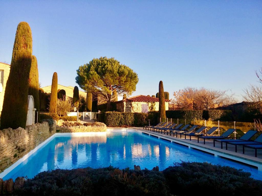 a swimming pool with lounge chairs in a yard at Bastidon à Gordes avec piscine in Gordes