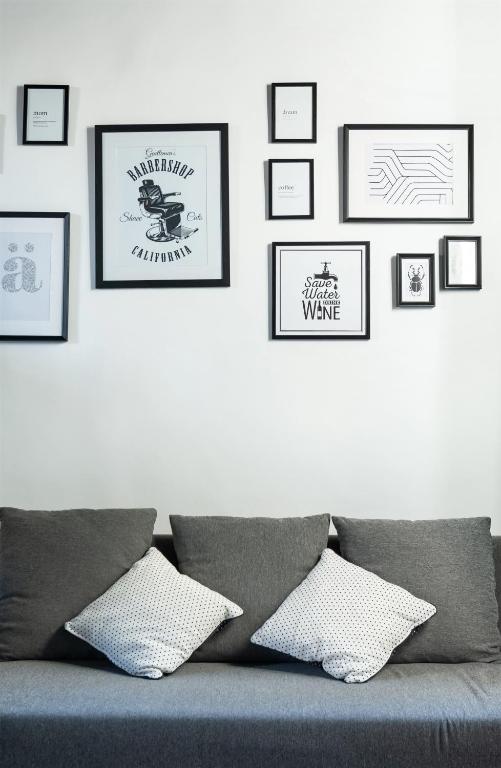 Pokój z kanapą i oprawionymi obrazami na ścianie w obiekcie Cozy studio Campo de Fiori w Rzymie
