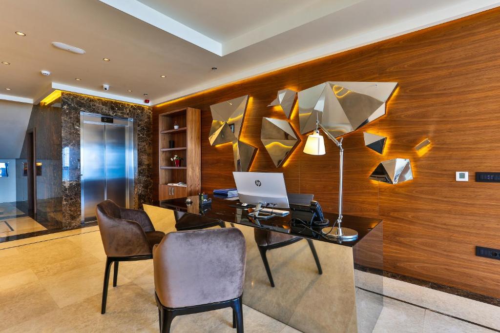 an office with a desk with a laptop and chairs at Hotel California by Aycon in Sveti Stefan