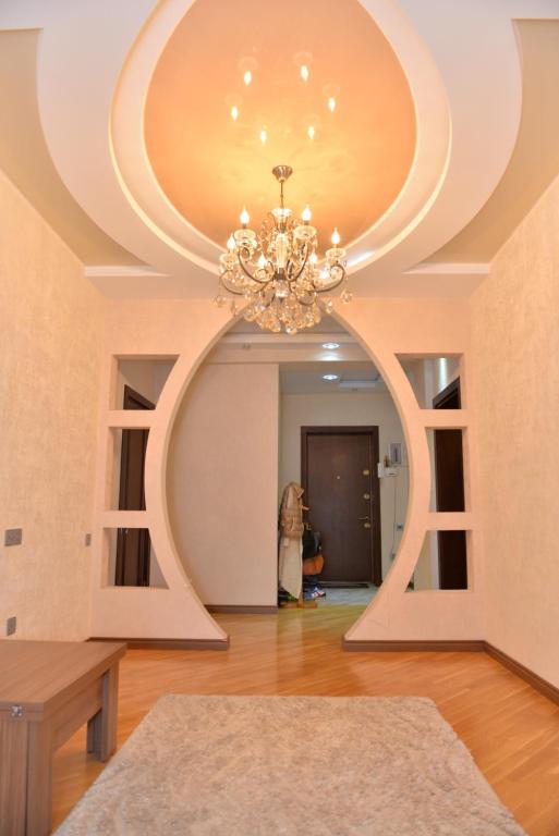 una sala de estar con una lámpara de araña en el techo en House Impulse Xazar, en Baku