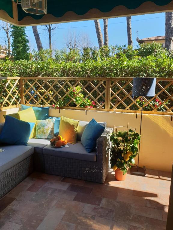 a couch sitting under an umbrella on a patio at Versilia Apartment in Forte dei Marmi