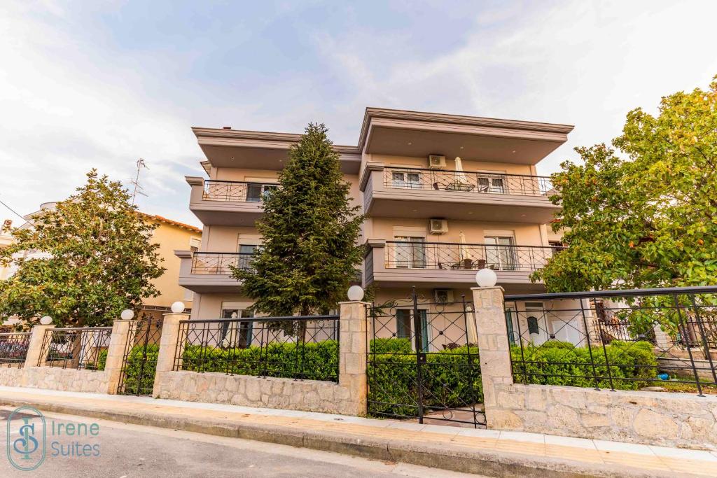 a building with a fence in front of it at Irene Suites in Nea Moudania