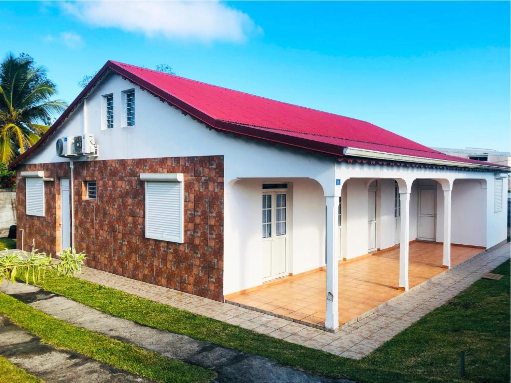 Casa blanca y roja con techo rojo en Jardin des Sucriers, en Trois-Rivières