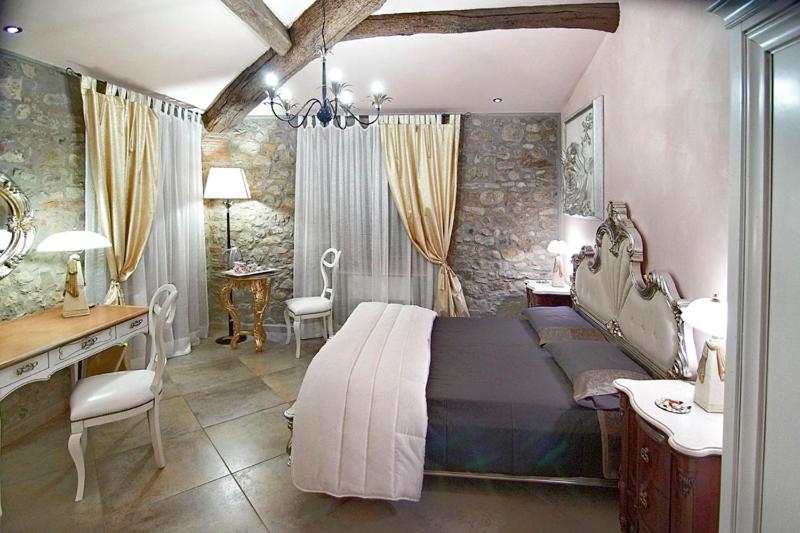 a bedroom with a bed and a desk and a sink at Strada Giulia 16 in Bolgheri