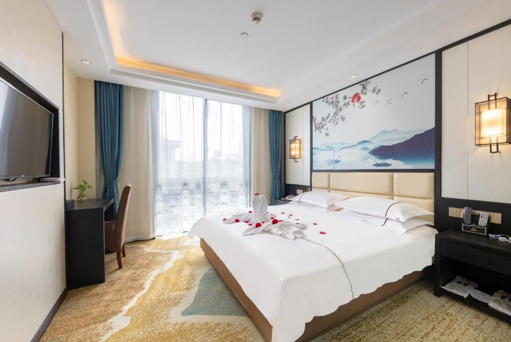 Postel nebo postele na pokoji v ubytování Yiwu Luckbear Hotel