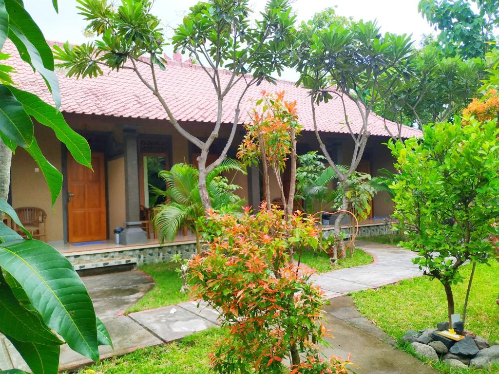 a house with a garden in front of it at Asih Homestay in Pemuteran
