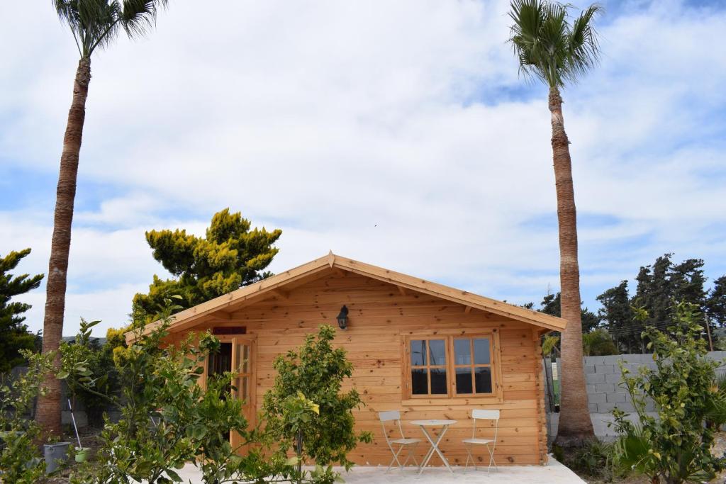 a log cabin with two palm trees at Cyprus Glamping Park in Ayios Theodhoros