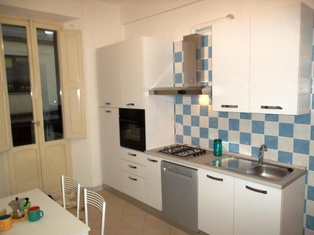 a kitchen with white cabinets and a sink and a table at Grottammare mon amour Levante in Grottammare