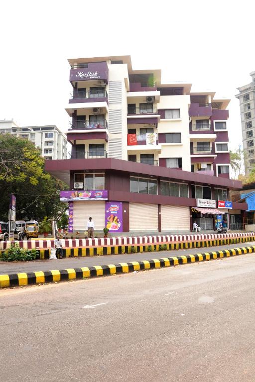a building with a yellow and black curb next to a street at Single Bedroom to rent in Two bedroom apartment in Udupi