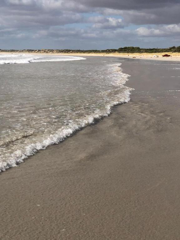 een strand met golven uit de oceaan bij Relaxarna in Robe