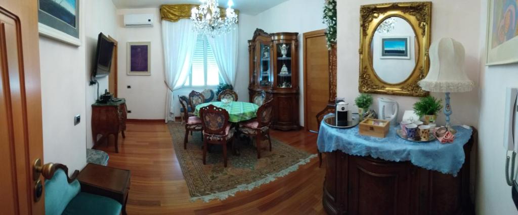un soggiorno con tavolo, sedie e specchio di Stella di mare a Cagliari