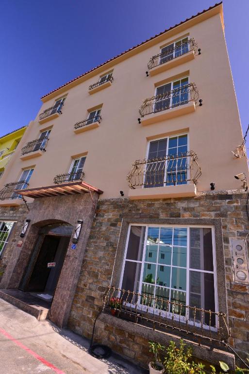 a building with windows and balconies on a street at Kenting Garden Homestay in Kenting