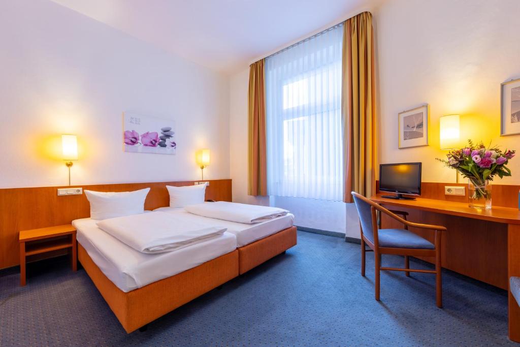 Una habitación de hotel con una cama, un escritorio y una computadora. en Trip Inn Hotel Schumann, en Düsseldorf