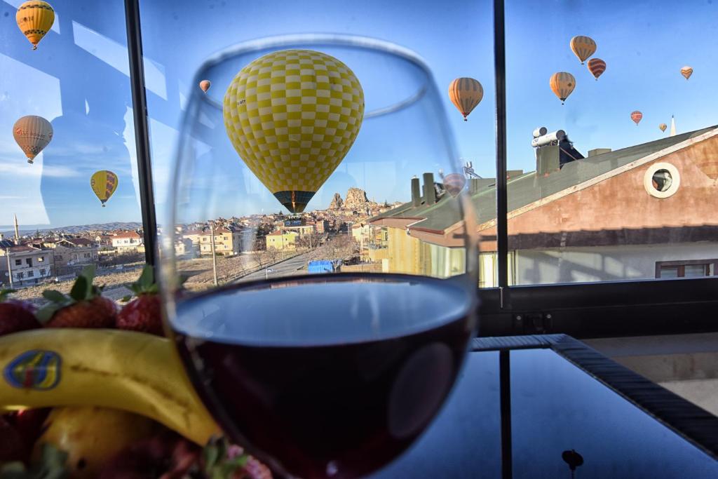 a glass of wine with a banana and hot air balloons at EL NAZAR STONE SUİTE in Uçhisar