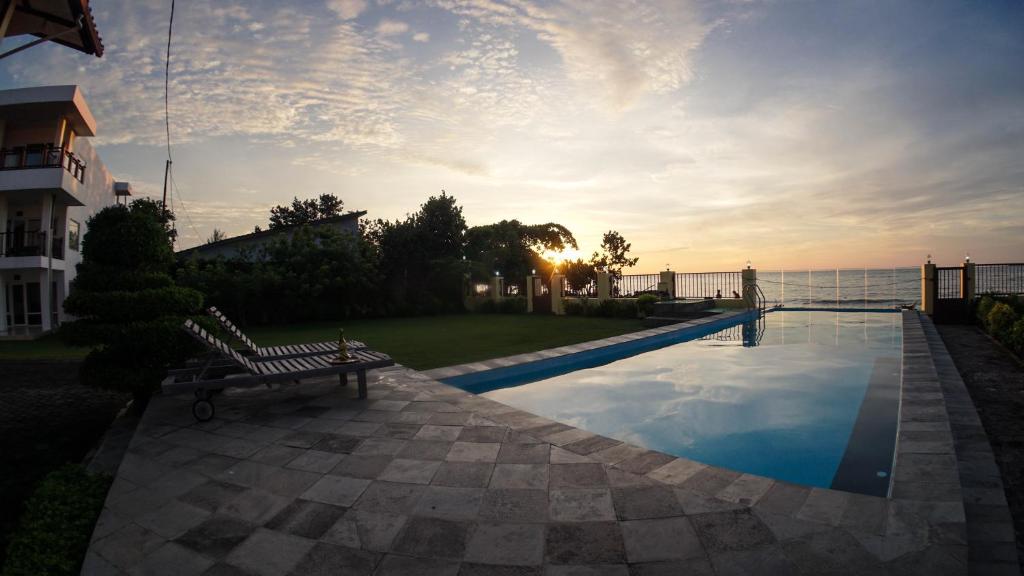 a bench sitting next to a swimming pool with the ocean at Jepara Marina Seaview in Jepara