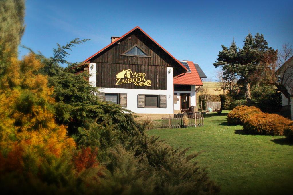 ein Haus mit einem Schild an der Seite in der Unterkunft Agro-zagroda in Strzyżów