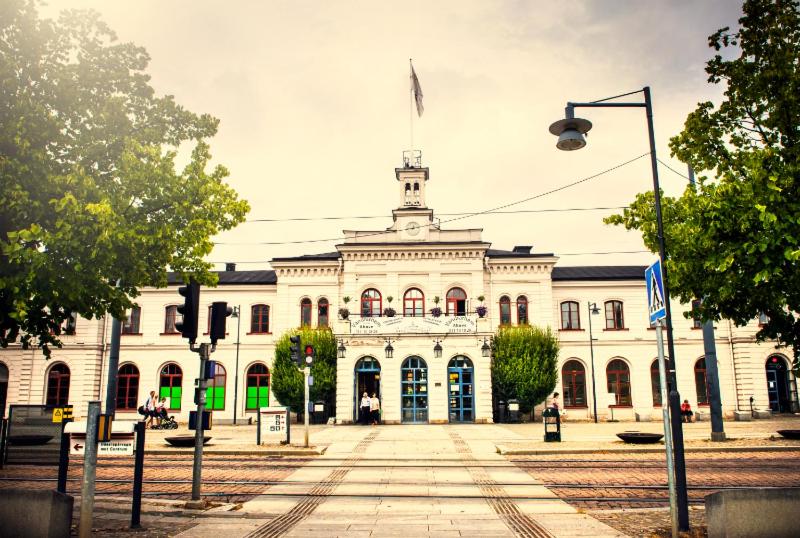 um grande edifício branco com uma bandeira em cima em Centralstationens Vandrarhem em Norrköping