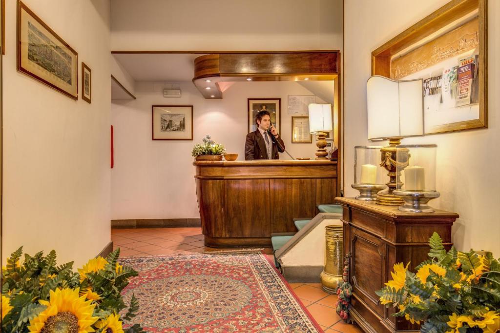 a man standing at a bar in a mirror at Hotel Rex in Florence