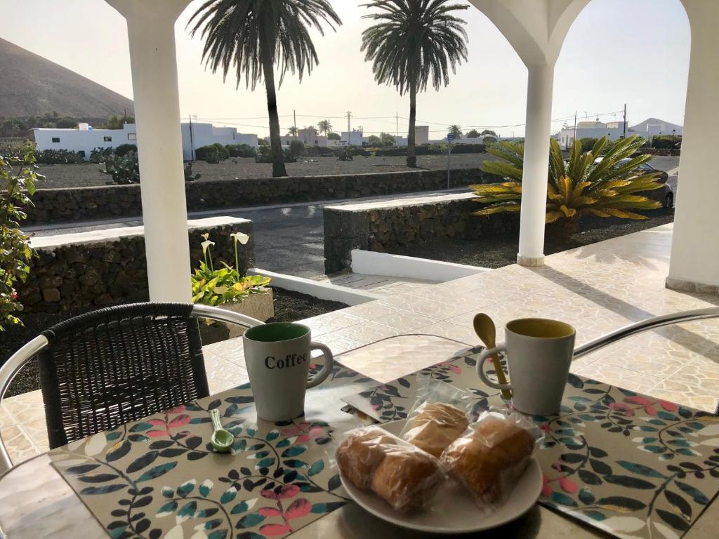 a table with a plate of croissants and cups on a patio at Love Yaiza in Yaiza