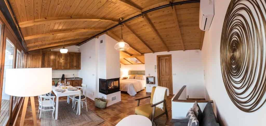 1 dormitorio y sala de estar con mesa de comedor. en La Buhardilla de Huecar, en Cuenca