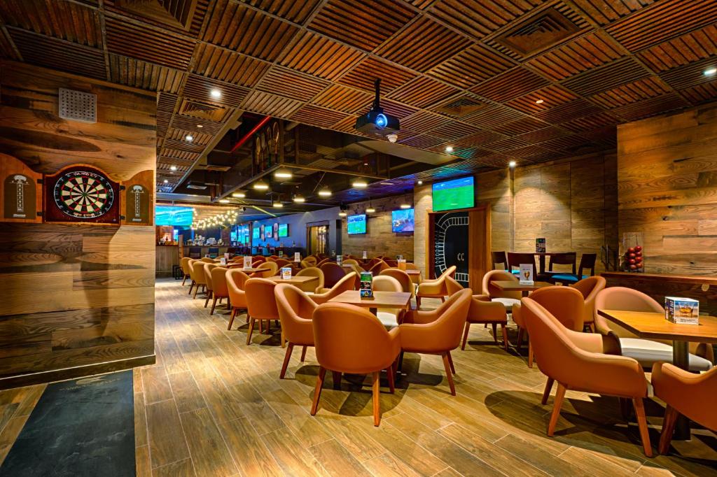a restaurant with chairs and tables and a clock at Citymax Hotel Bur Dubai in Dubai