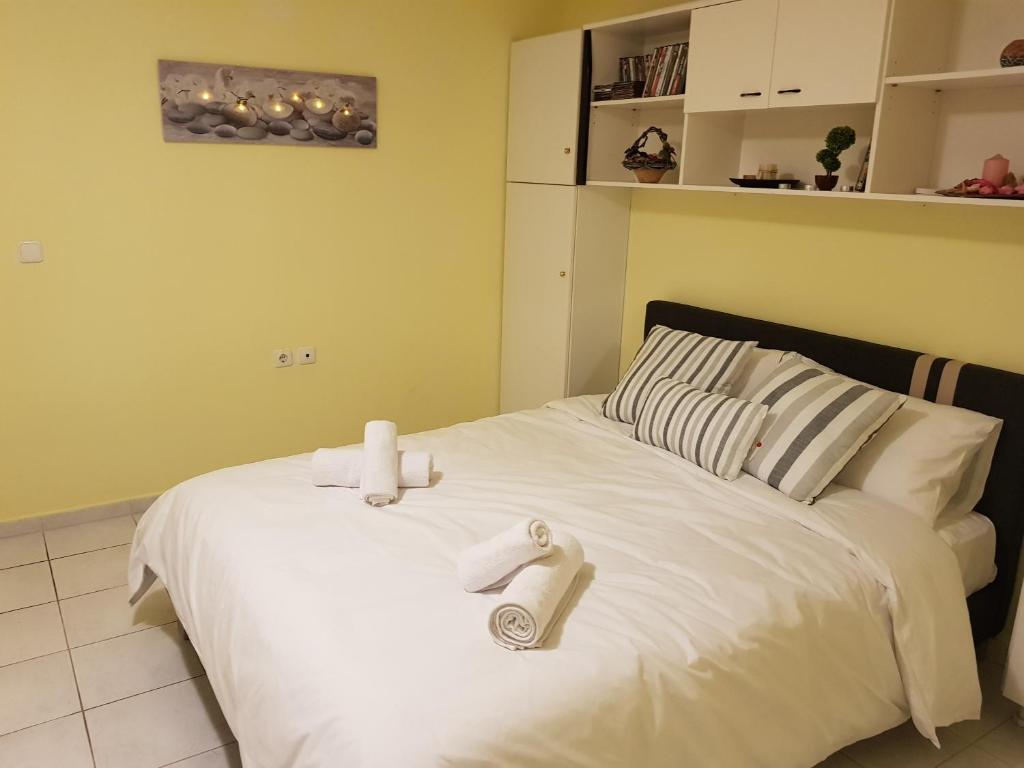 ein Schlafzimmer mit einem weißen Bett und Handtüchern darauf in der Unterkunft COZZY STUDIO IN NEA MAKRI in Nea Makri