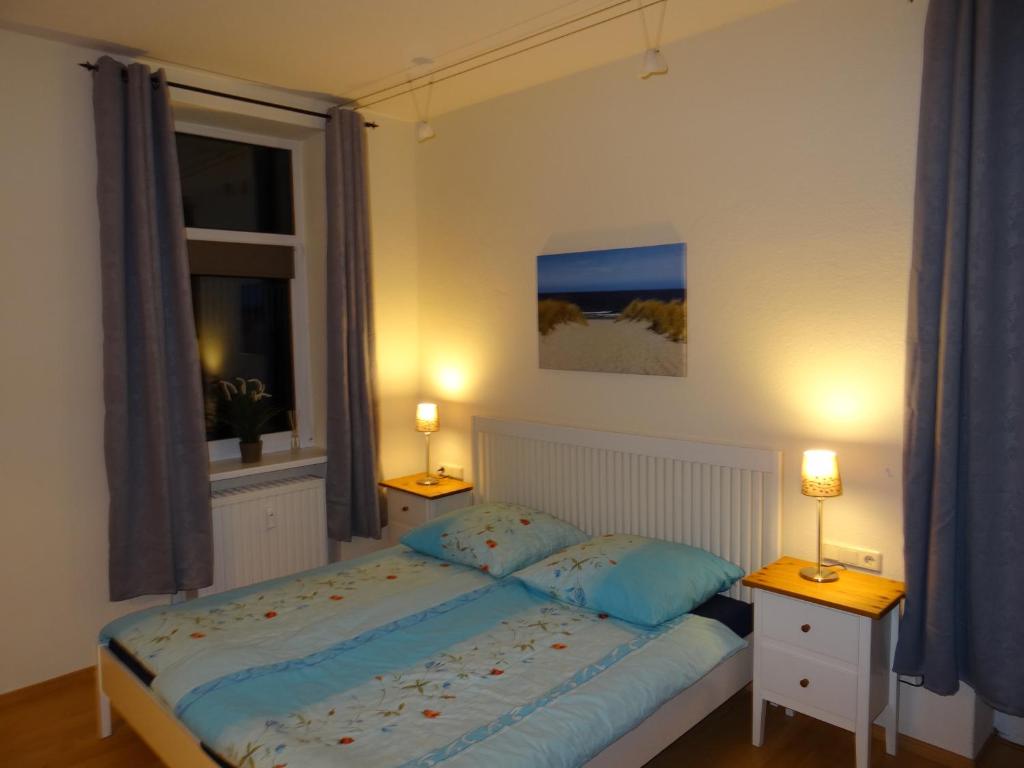 a bedroom with a bed and two night stands and a window at Fürstenhof Fewo Beagle in Sassnitz
