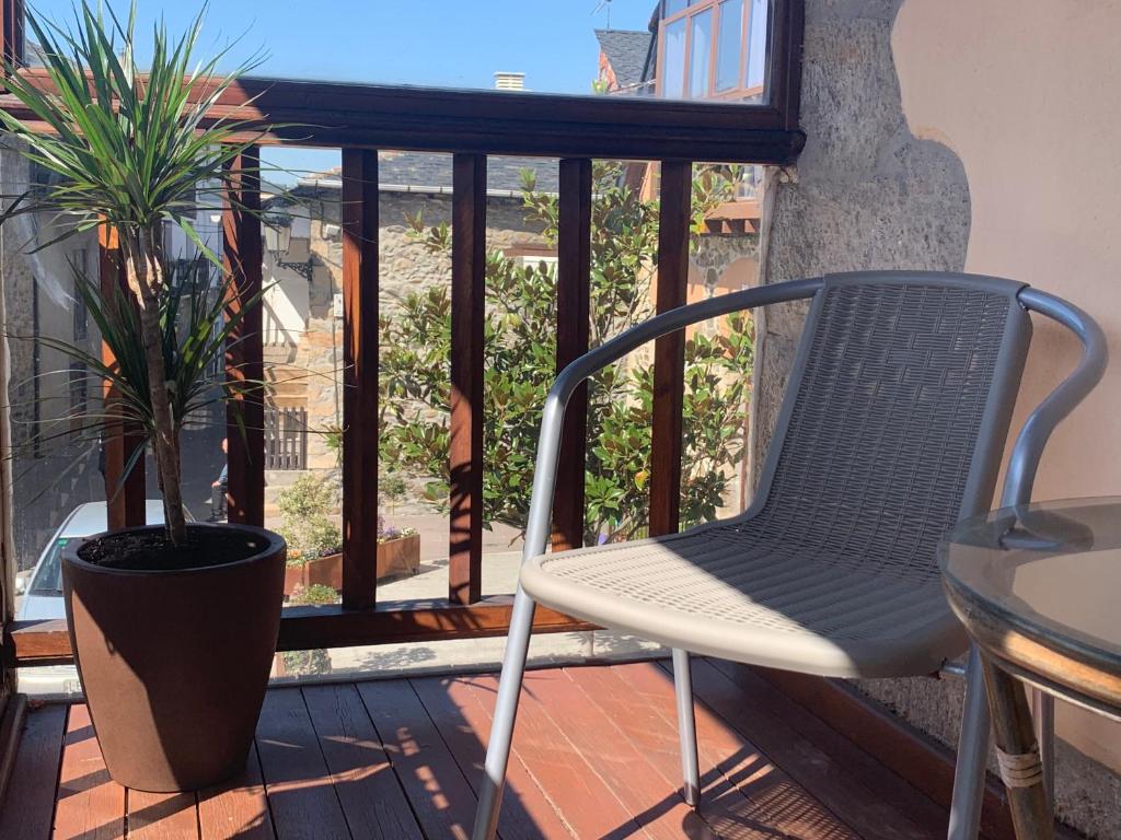 a chair and a plant on a balcony at Hostal Casa San Nicolas in Molinaseca