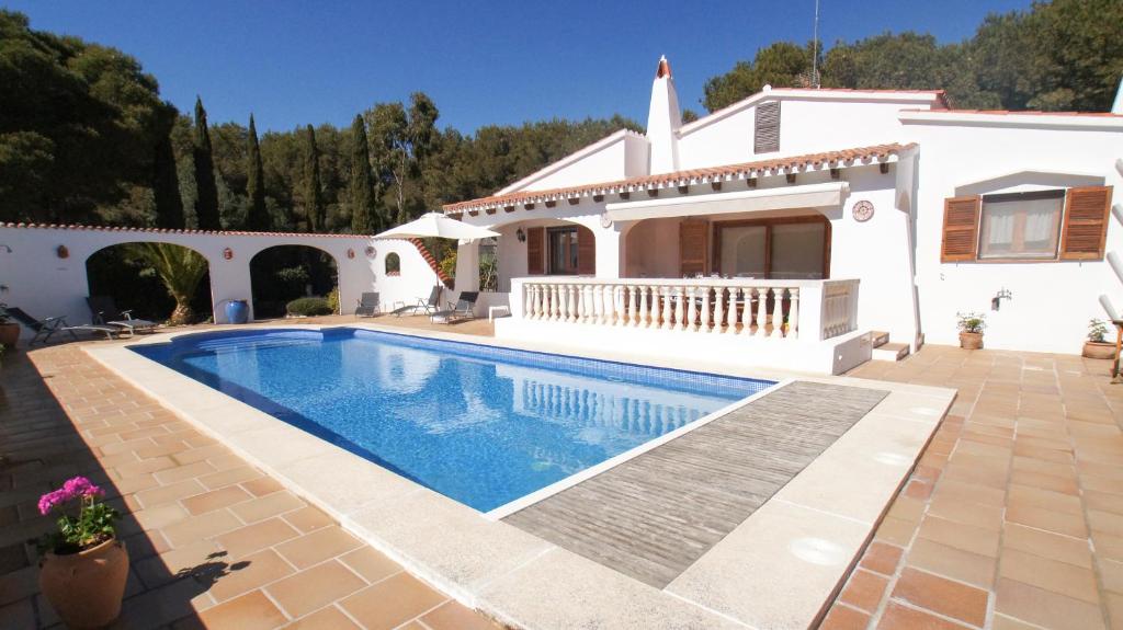 a villa with a swimming pool in front of a house at Marmirada in Sant Lluis