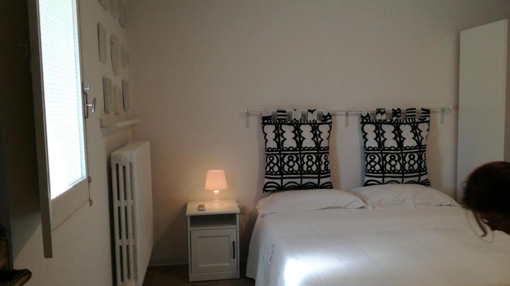 1 dormitorio con 1 cama y 1 mesa con lámpara en Numero 21, en Andria