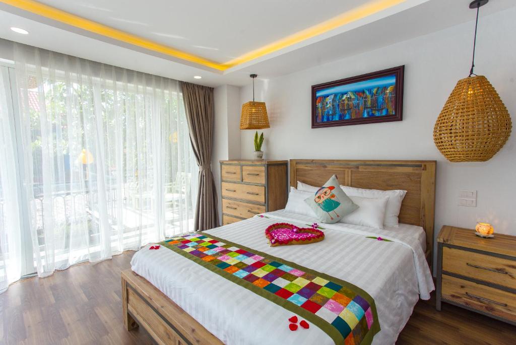 um quarto com uma cama grande e uma janela em Peach House em Hoi An