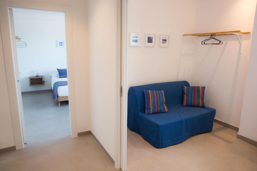 a blue chair in a room with a bedroom at Cocor Suites & Design in Naples