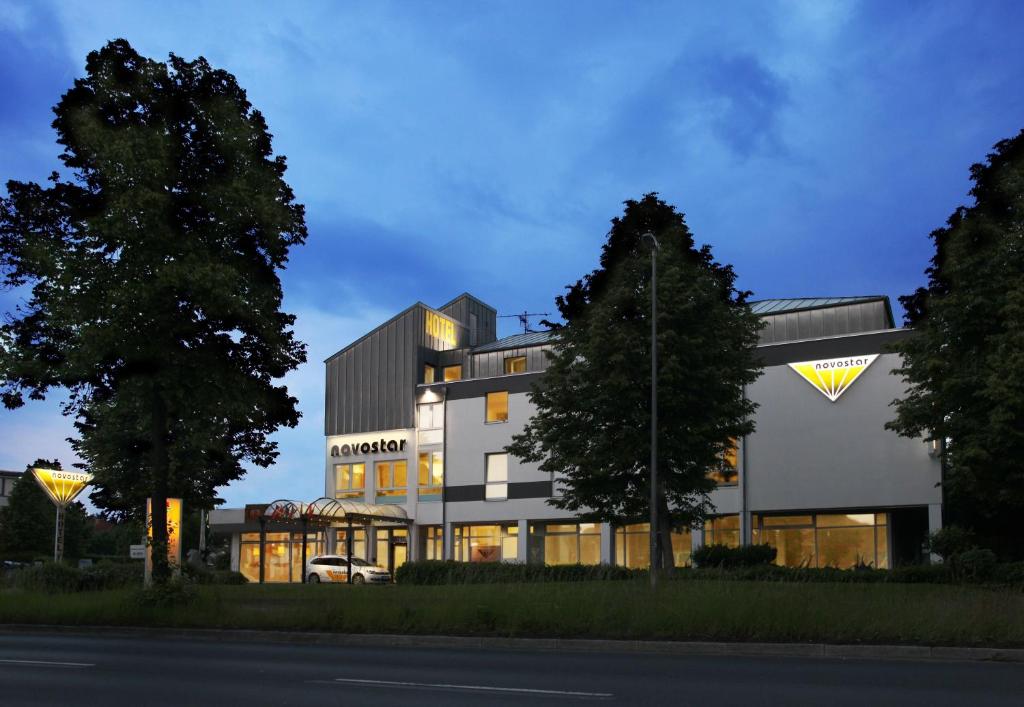 ein großes weißes Gebäude mit Bäumen davor in der Unterkunft Hotel Novostar in Göttingen