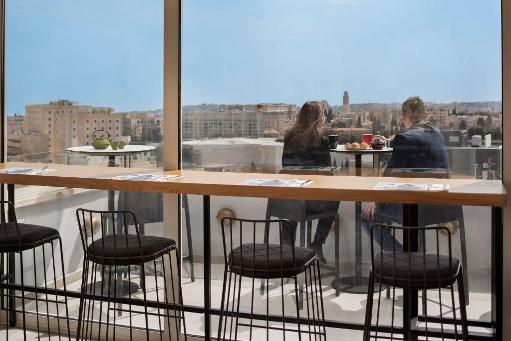 a bar with chairs and a view of a city at Ibis Styles Jerusalem City Center - An AccorHotels Brand in Jerusalem