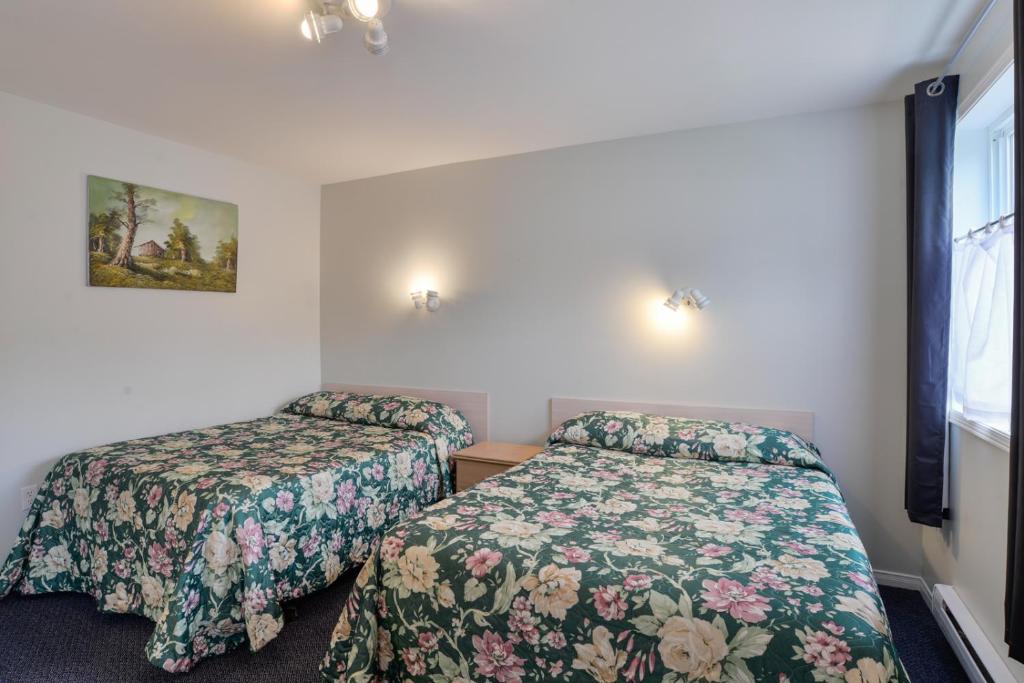 a bedroom with two beds and a window at Oakwood Motel in Gravenhurst