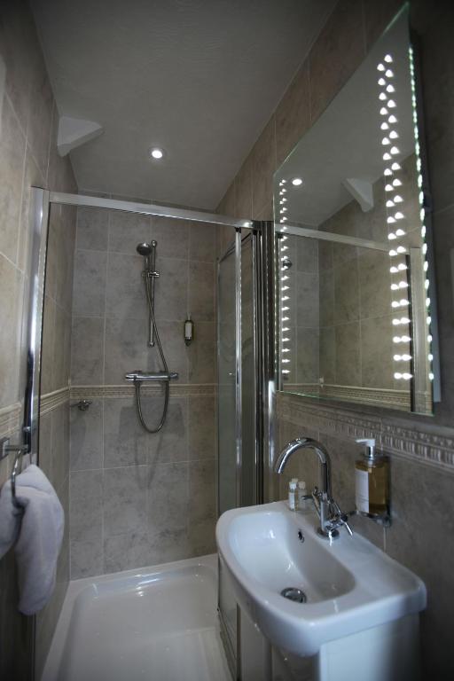 a bathroom with a sink and a shower with a mirror at Fernhill Hotel in Lyme Regis