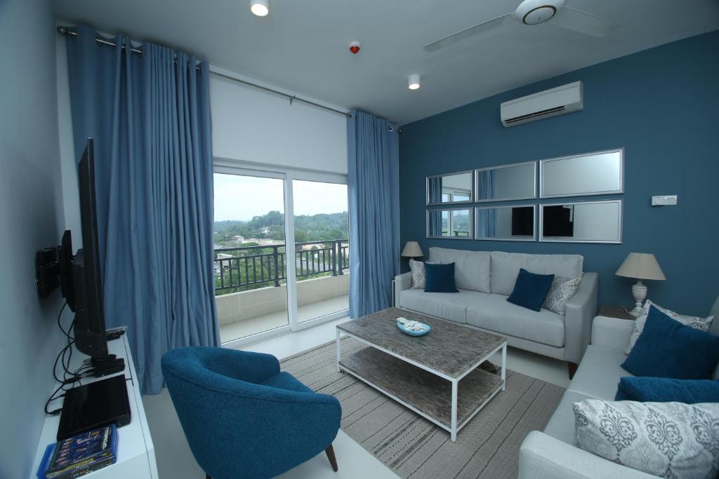 a living room with a couch and a large window at HummingBird Holiday Apartment in Galle