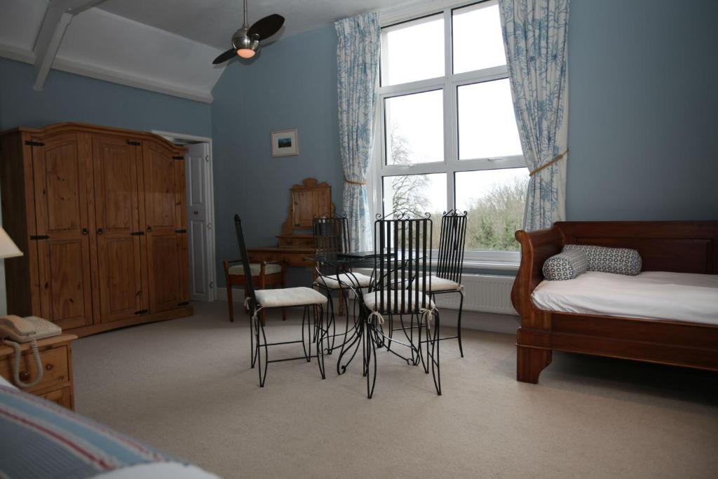a room with a table and chairs and a window at Fernhill Hotel in Lyme Regis