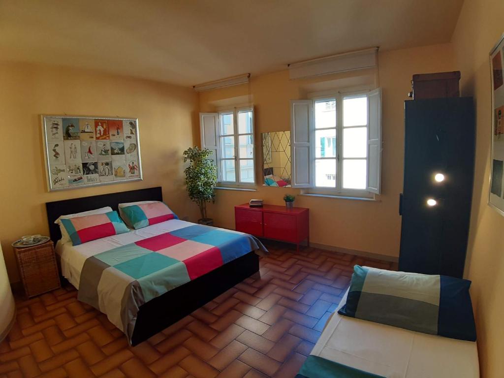 een slaapkamer met een bed en 2 ramen bij Francesca House in Pisa