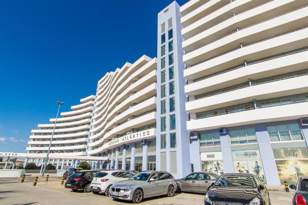 un estacionamiento con autos estacionados frente a edificios altos en Atlantic Sun & Love Apartment, en Portimão