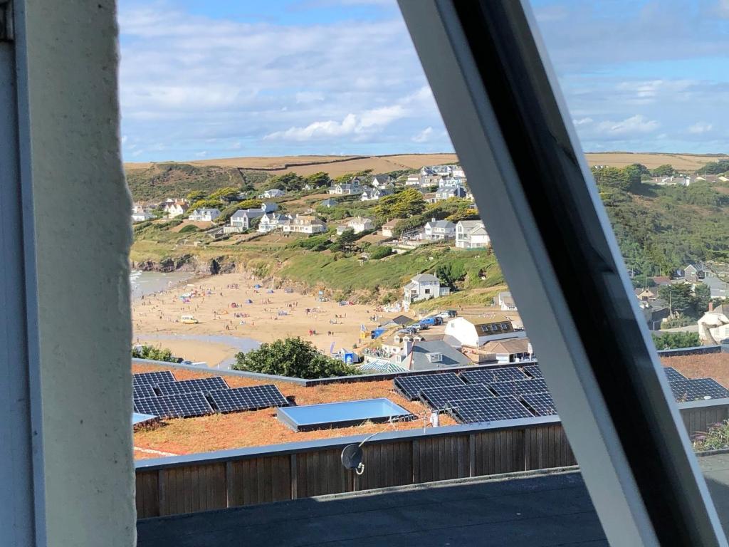 a view from a window of a beach and buildings at Westward 14 Polzeath in Polzeath