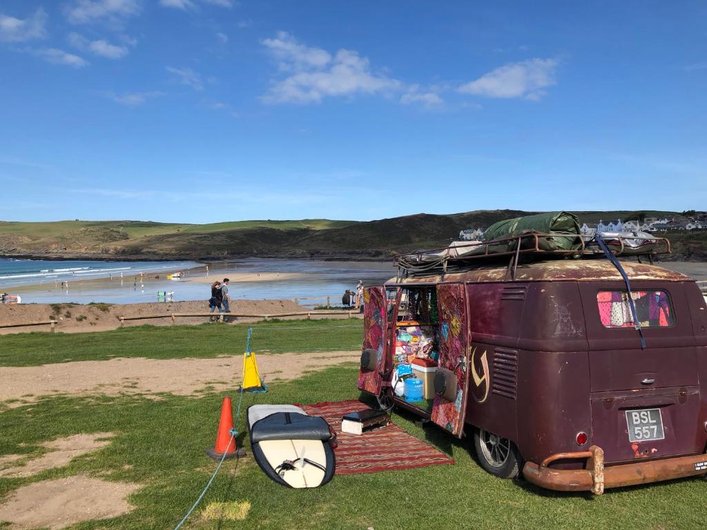 a van parked on the grass next to a beach at Westward 14 Polzeath in Polzeath