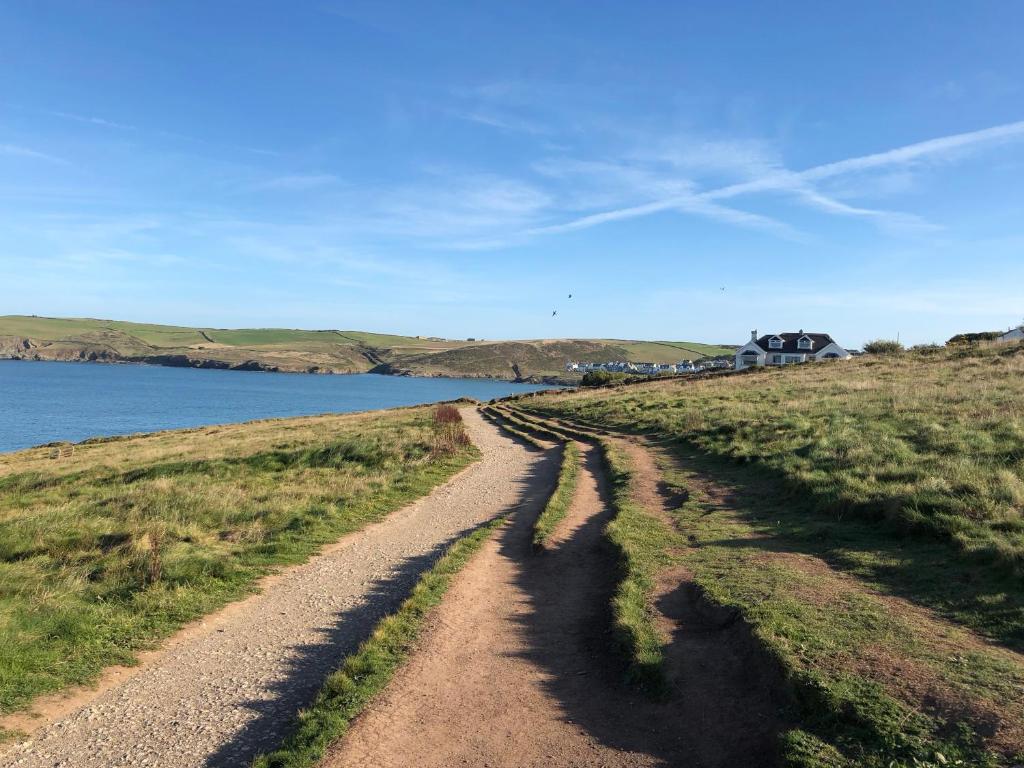 a dirt road next to a body of water at Westward 14 Polzeath in Polzeath