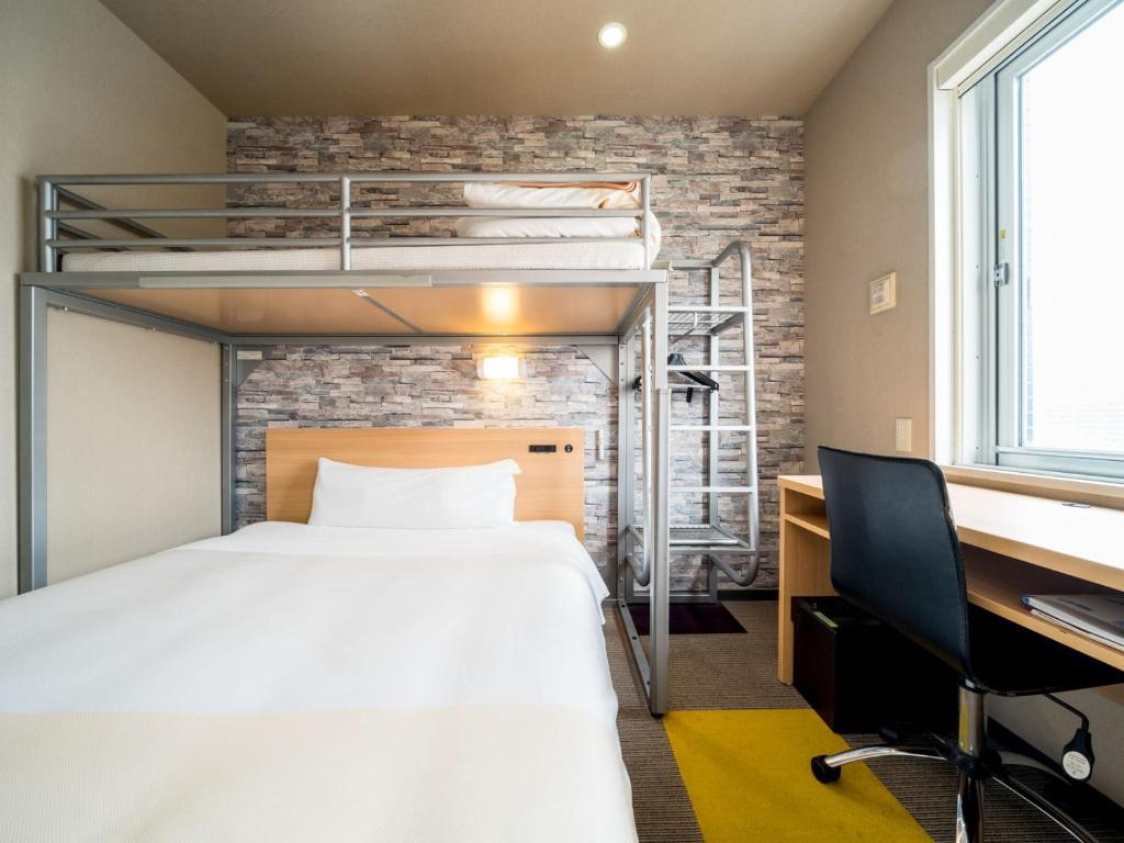 a bedroom with a bed and a desk and a bunk bed at Super Hotel Takamatsu Kin en kan in Takamatsu