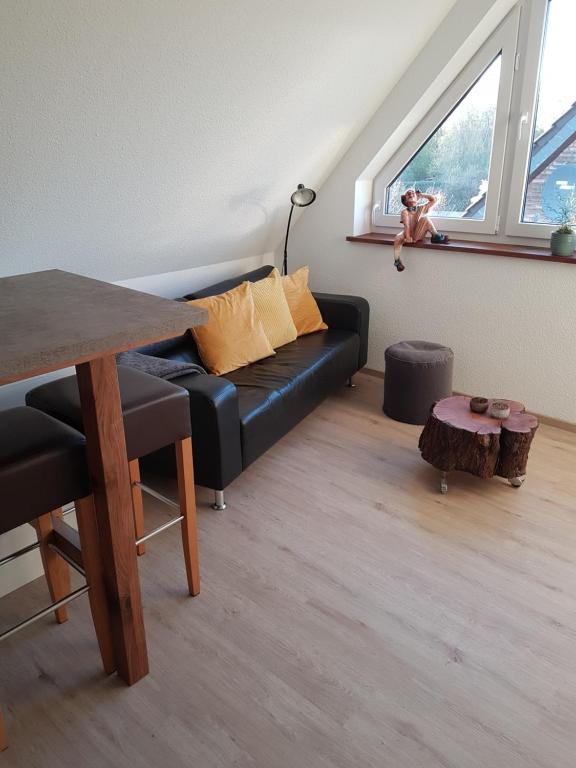 ein Wohnzimmer mit einem schwarzen Sofa und einem Fenster in der Unterkunft DOMizil Xanten in Xanten